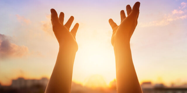 Respect and pray on the sunset in city background